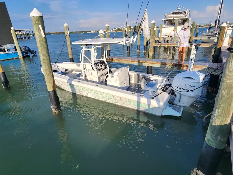 Slide: The Image of 2006 Everglades 243 CC boat docked in a marina with clear blue water. - 1