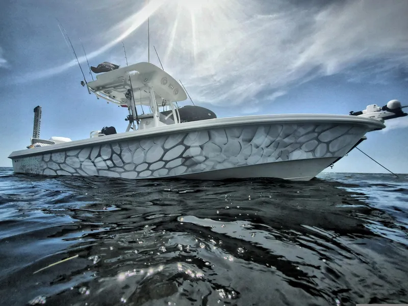 Slide: The Image of 2006 Everglades 243 CC boat on water with unique patterned hull design. - 11