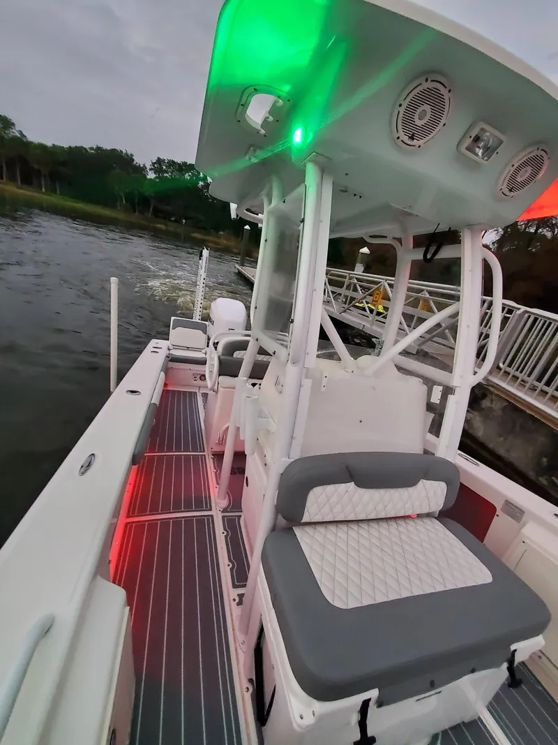 Slide: The Image of 2006 Everglades 243 CC boat with illuminated deck and seating, docked by the water. - 16