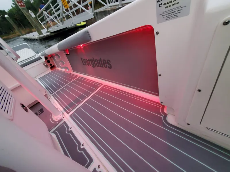 Slide: The Image of 2006 Everglades 243 CC boat interior with red LED lighting and gray flooring. - 30