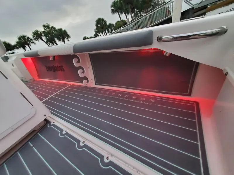 Slide: The Image of 2006 Everglades 243 CC boat interior with red LED lighting and cushioned seating. - 35