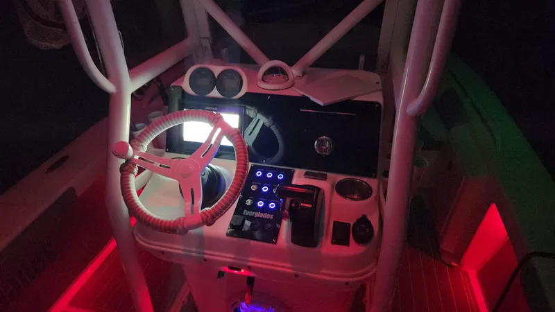Slide: The Image of 2006 Everglades 243 CC boat cockpit with illuminated controls and steering wheel at night. - 5