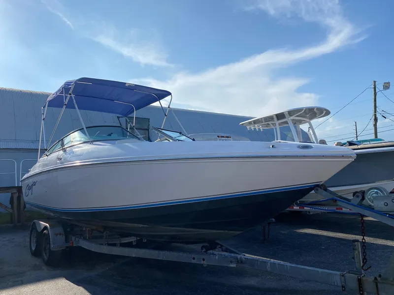 Slide: The Image of 2016 Baja 23 Islander boat on trailer with blue canopy in marina. - 3