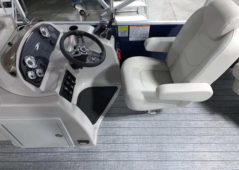Slide: The Image of 2024 Starcraft EX22 FD boat cockpit with steering wheel and captain's chair. - 11