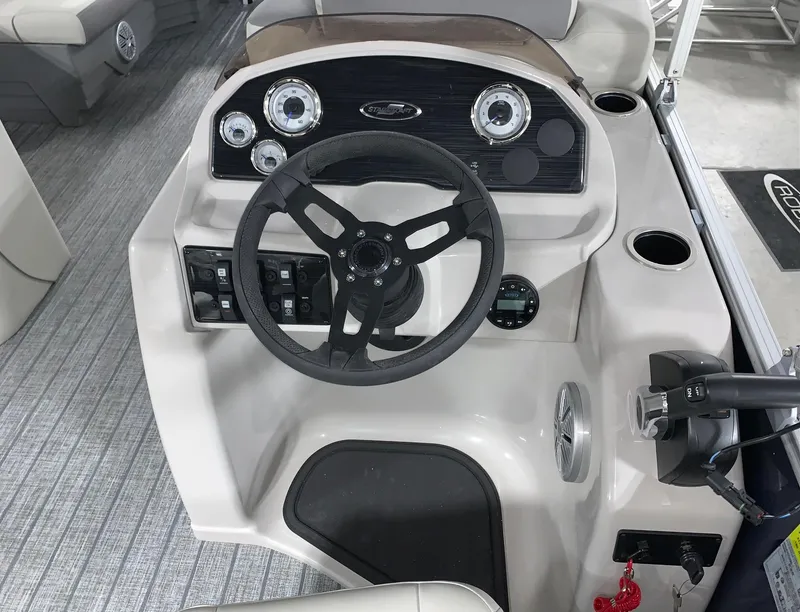 Slide: The Image of 2024 Starcraft EX22 FD boat dashboard with steering wheel and control panel. - 12
