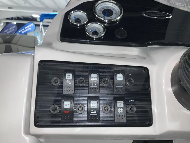 Slide: The Image of 2024 Starcraft EX22 FD boat dashboard with control switches and gauges. - 13