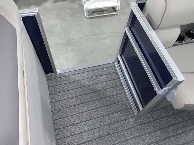 Slide: The Image of 2024 Starcraft EX22 FD boat interior with open side gate and gray flooring. - 16