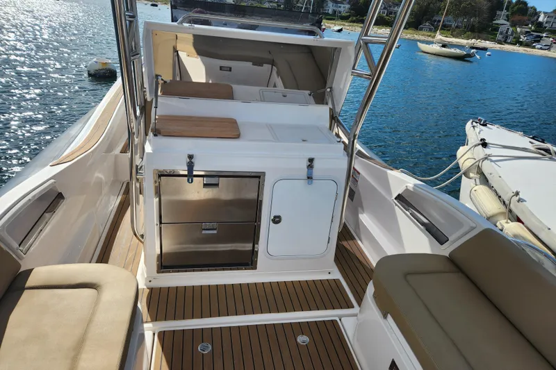 Slide: The Image of 2020 Zar Formenti 85 SL boat interior with seating and storage, docked by the water. - 22