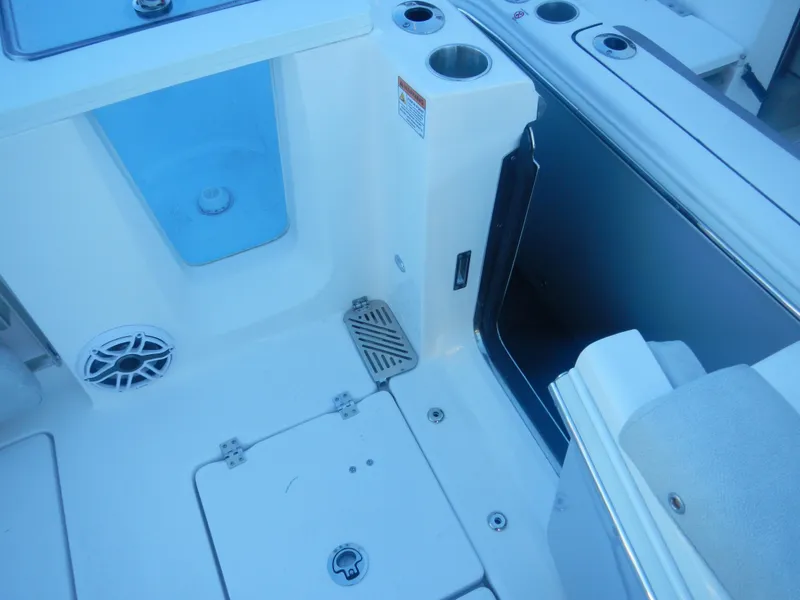 Slide: The Image of 2024 Sea Fox 328 Commander boat interior, featuring storage compartments and cup holders. - 14