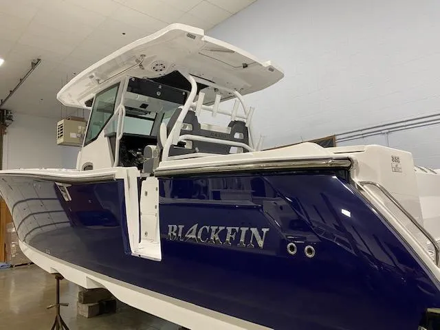 Slide: The Image of 2023 Blackfin 332 CC boat in showroom, side view. - 1