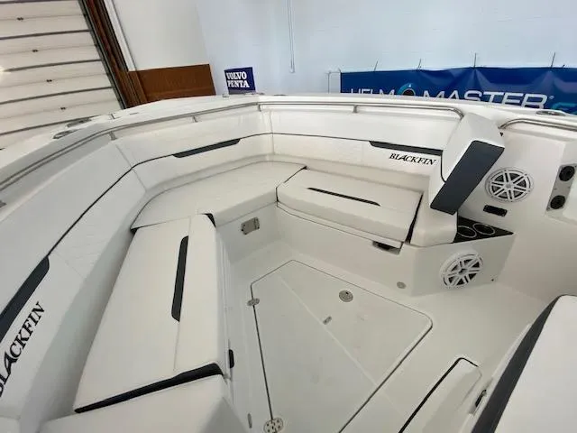 Slide: The Image of 2023 Blackfin 332 CC boat interior with white cushioned seating and storage compartments. - 10