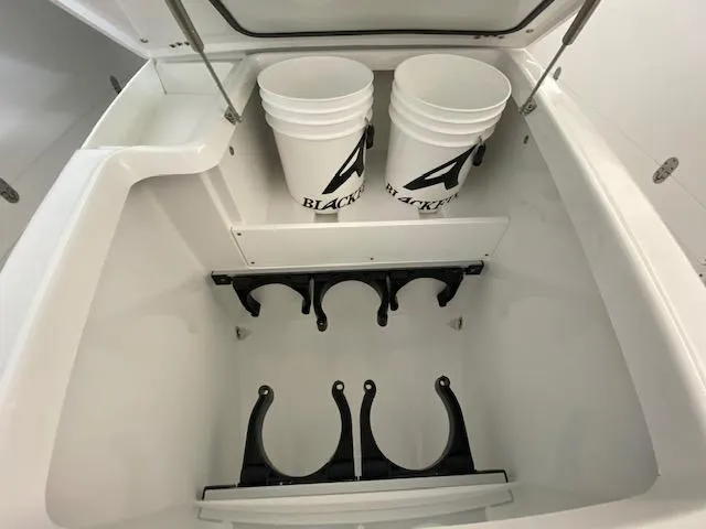 Slide: The Image of 2023 Blackfin 332 CC storage compartment with buckets and rod holders. - 8