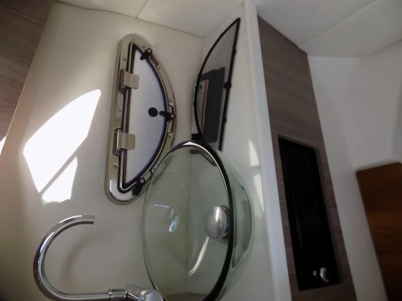 Slide: The Image of 2023 Regal 29 OBX boat interior with modern glass sink and porthole window. - 7
