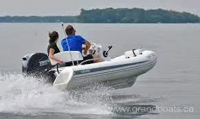 Slide: The Image of 2022 Grand G380 inflatable boat speeding on a lake with two passengers. - 7