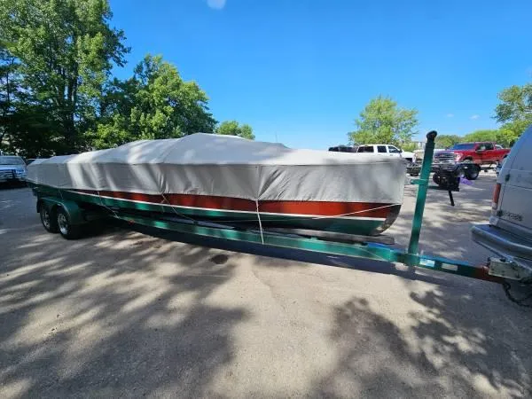 Slide: The Image of 1989 Hacker-Craft Triple Cockpit boat covered on a trailer in a parking lot. - 24