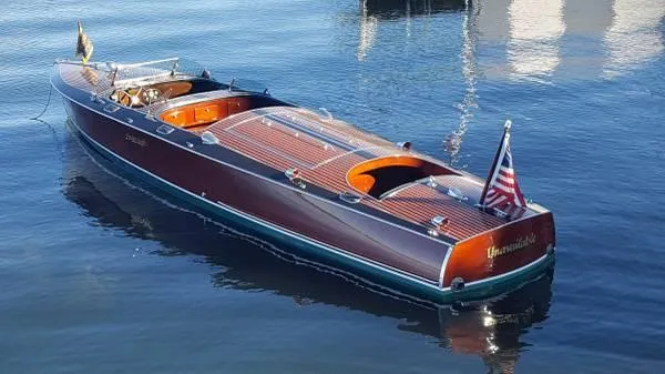 Slide: The Image of 1989 Hacker-Craft Triple Cockpit boat on water, featuring classic wooden design and American flag. - 5