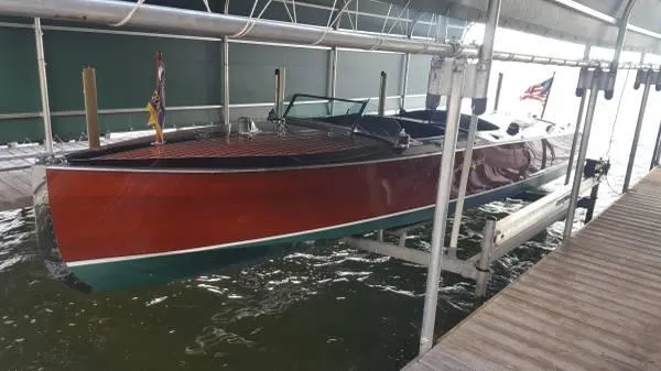 Slide: The Image of 1989 Hacker-Craft Triple Cockpit boat docked, showcasing classic wooden design and American flag. - 6