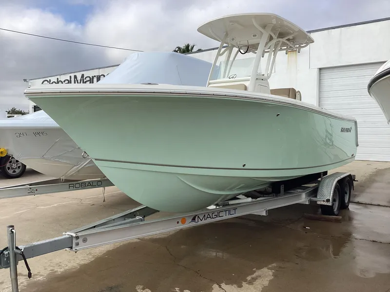 The Image of 2021 Sailfish 241CC boat on trailer at marina, light green hull. - 0