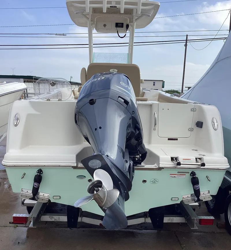 Slide: The Image of 2021 Sailfish 241CC boat with outboard motor, docked on trailer. - 2