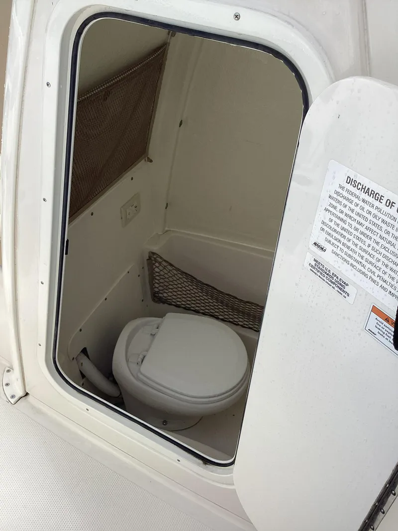 Slide: The Image of 2021 Sailfish 241CC boat interior with compact marine toilet. - 8