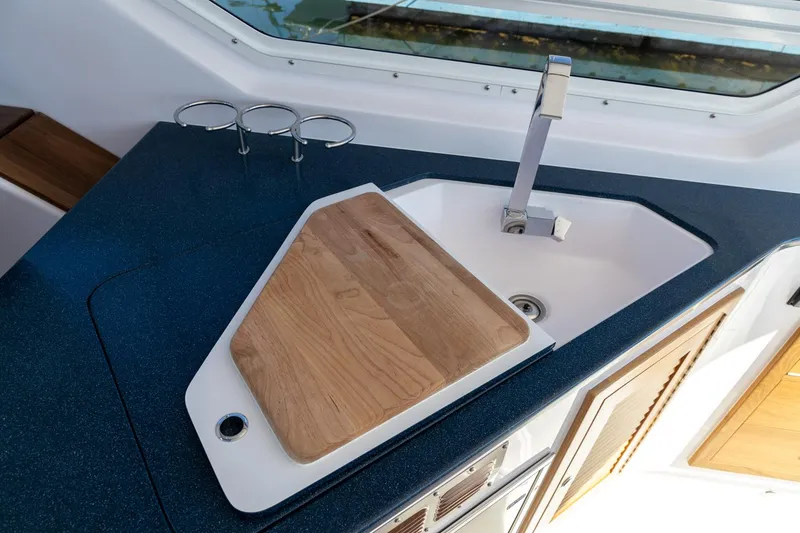 Slide: The Image of Modern boat kitchen with sink, cutting board, and sleek countertop, True North 34, 2020 model. - 16