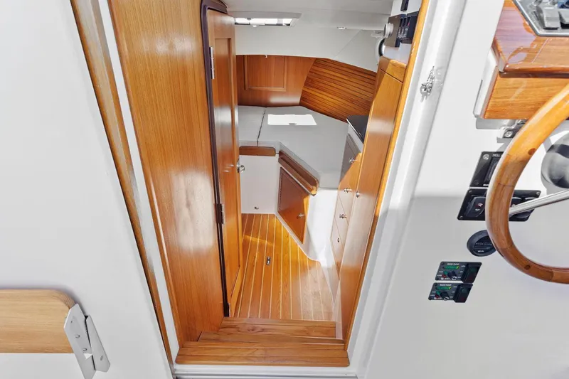 Slide: The Image of Interior view of 2020 True North 34 boat with wooden finishes and compact cabin space. - 17