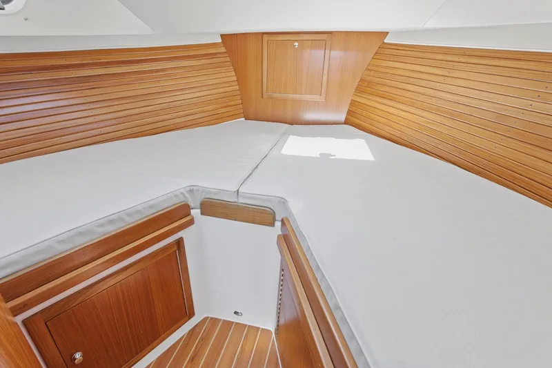 Slide: The Image of Cozy cabin interior of 2020 True North 34 boat with wooden paneling and white bedding. - 18