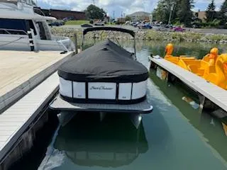 The Image of 2021 SunChaser Geneva Sport 22 LR DH pontoon boat docked with cover. - 0