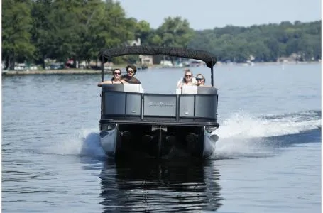 Slide: The Image of 2021 SunChaser Geneva Sport 22 LR DH pontoon boat cruising on a lake. - 14