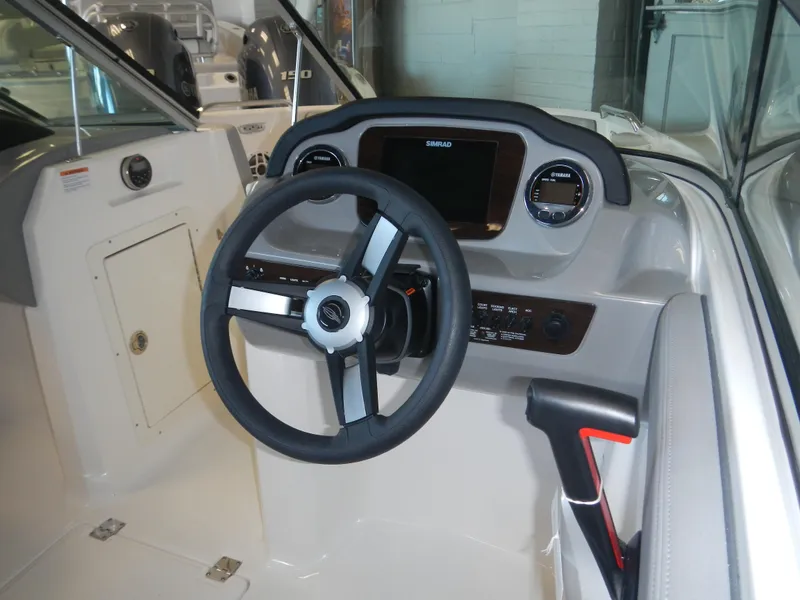 Slide: The Image of 2024 Chaparral 21 SSi boat cockpit with steering wheel and dashboard. - 2