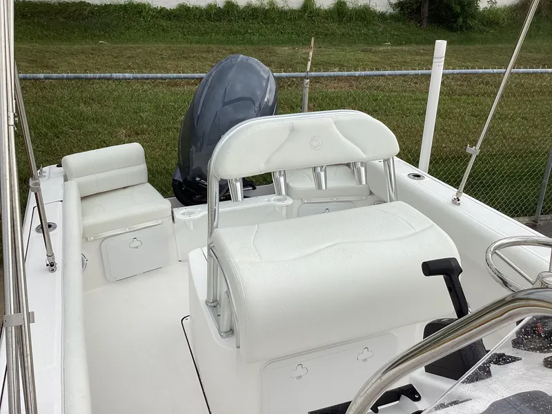 Slide: The Image of 2023 Edgewater 188CC boat interior with white seating and outboard motor. - 2