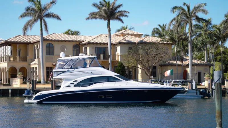 The Image of 2005 Sea Ray 550 Sedan Bridge yacht docked near luxury waterfront homes. - 0