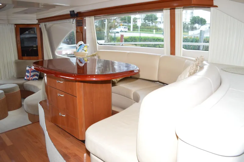 Slide: The Image of Luxurious interior of 2005 Sea Ray 550 Sedan Bridge with leather seating and wooden table. - 4