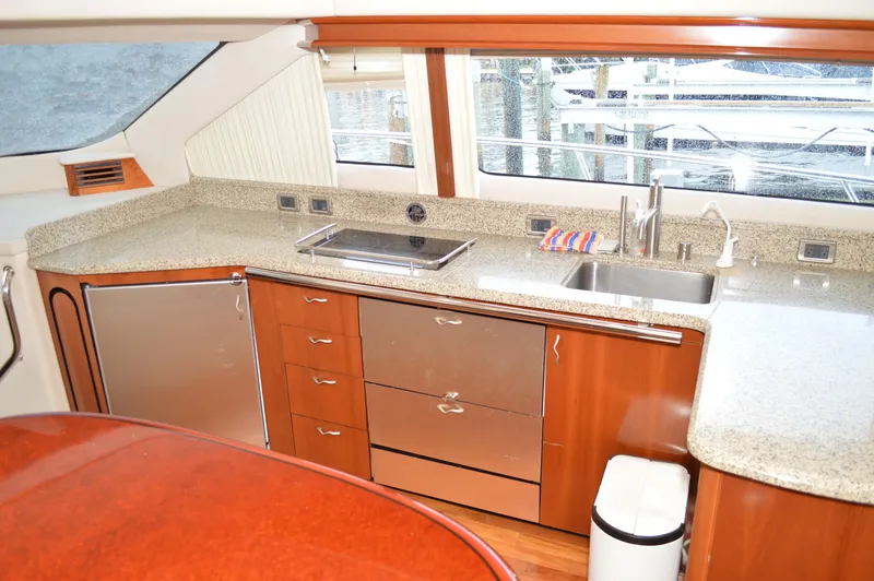 Slide: The Image of 2005 Sea Ray 550 Sedan Bridge yacht kitchen with granite countertops and stainless steel appliances. - 6