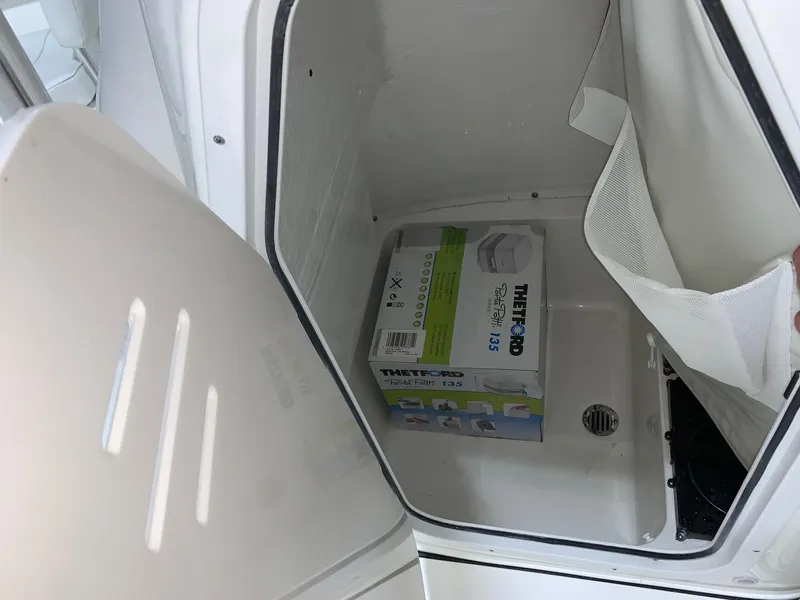 Slide: The Image of 2024 Key West 203 FS storage compartment with Thetford Porta Potti. - 17
