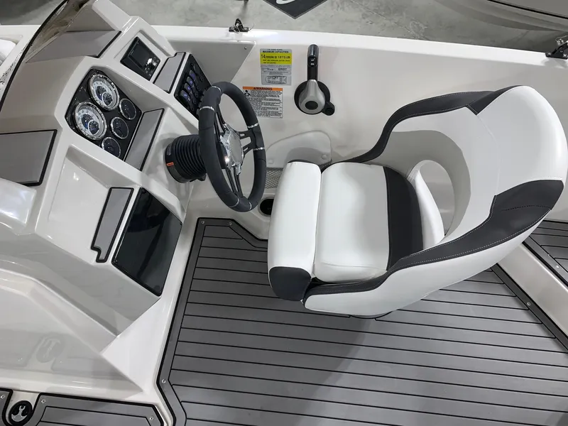 Slide: The Image of 2024 Starcraft SVX 211 boat cockpit with steering wheel and captain's chair. - 13