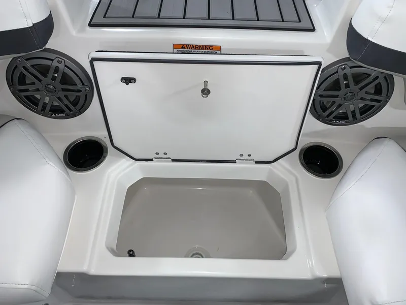 Slide: The Image of 2024 Starcraft SVX 211 boat interior with storage compartment, speakers, and cup holders. - 16