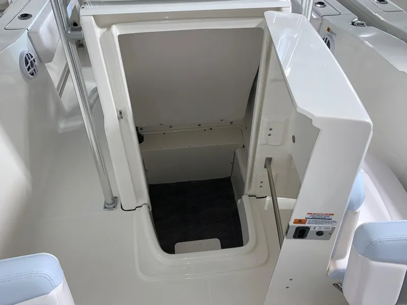 Slide: The Image of 2024 Robalo R202 Explorer boat storage compartment with open hatch. - 12