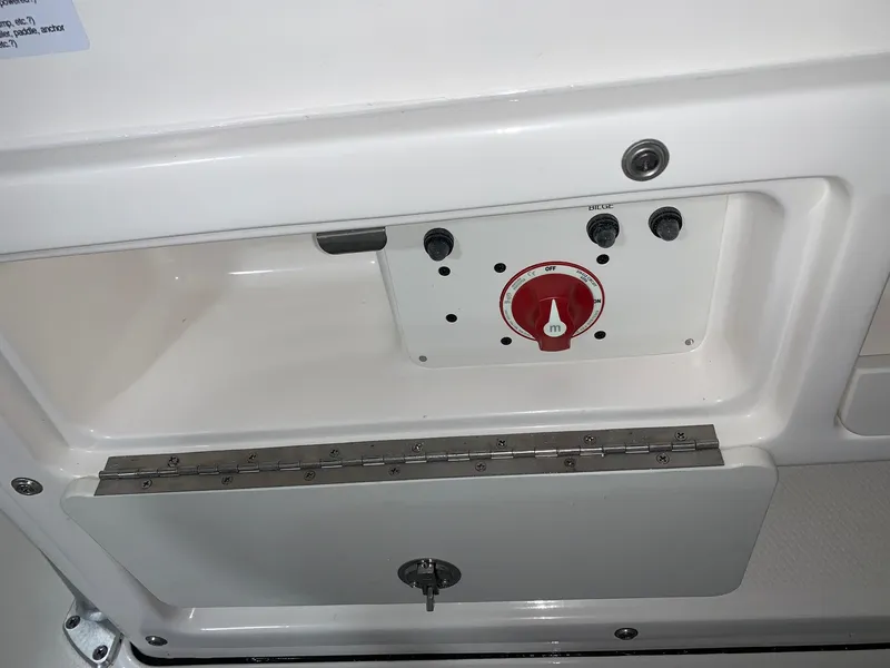 Slide: The Image of 2024 Robalo R202 Explorer control panel with red switch and storage compartment. - 18
