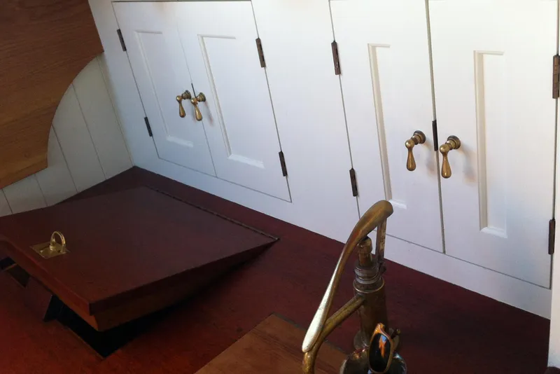 Slide: The Image of Interior of 1902 Herreshoff Gaff Cutter with brass fixtures and wooden cabinetry. - 23
