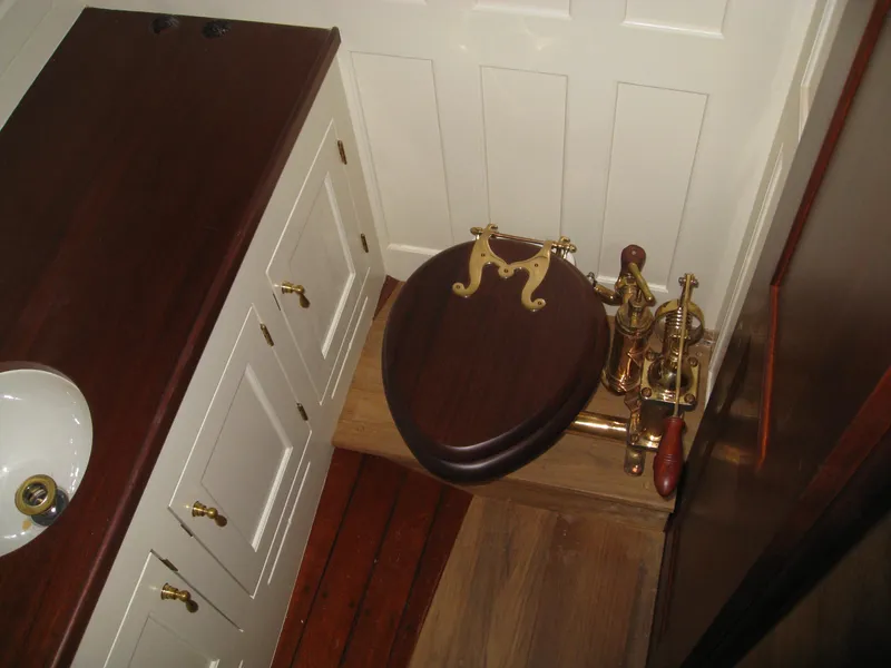 Slide: The Image of Vintage Herreshoff Gaff Cutter 1902 bathroom with wooden toilet seat and brass fixtures. - 25
