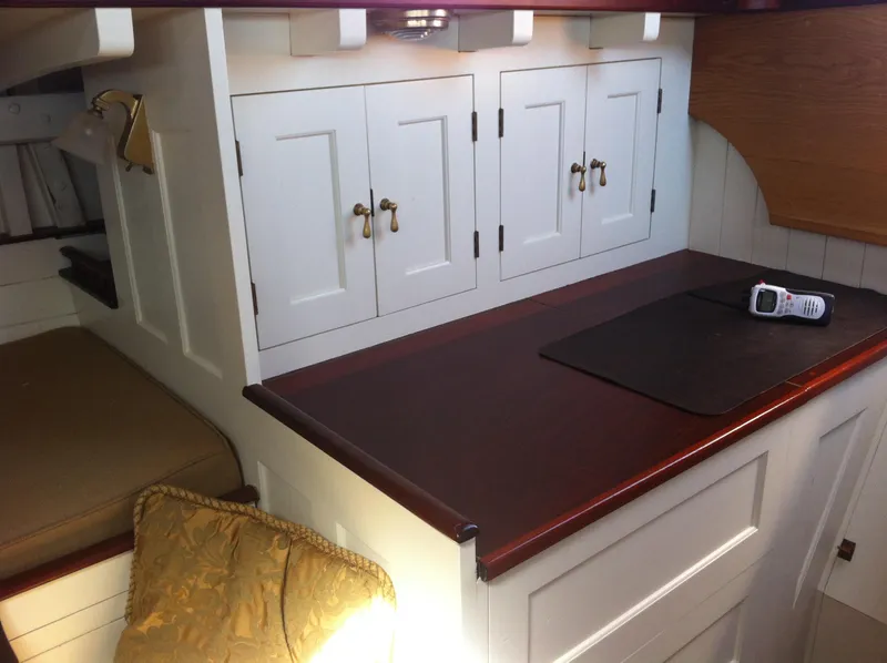 Slide: The Image of Interior of 1902 Herreshoff Gaff Cutter with wooden cabinetry and a radio on the counter. - 27
