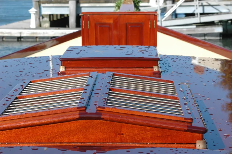 Slide: The Image of 1902 Herreshoff Gaff Cutter deck with polished wood and raindrops. - 8