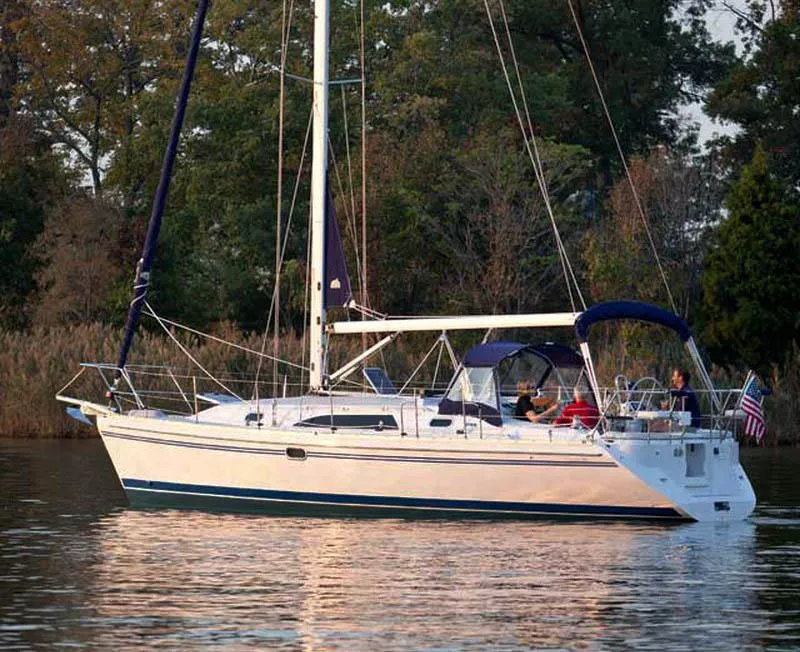 Slide: The Image of 2025 Catalina 356 sailboat on calm water, surrounded by lush greenery. - 5