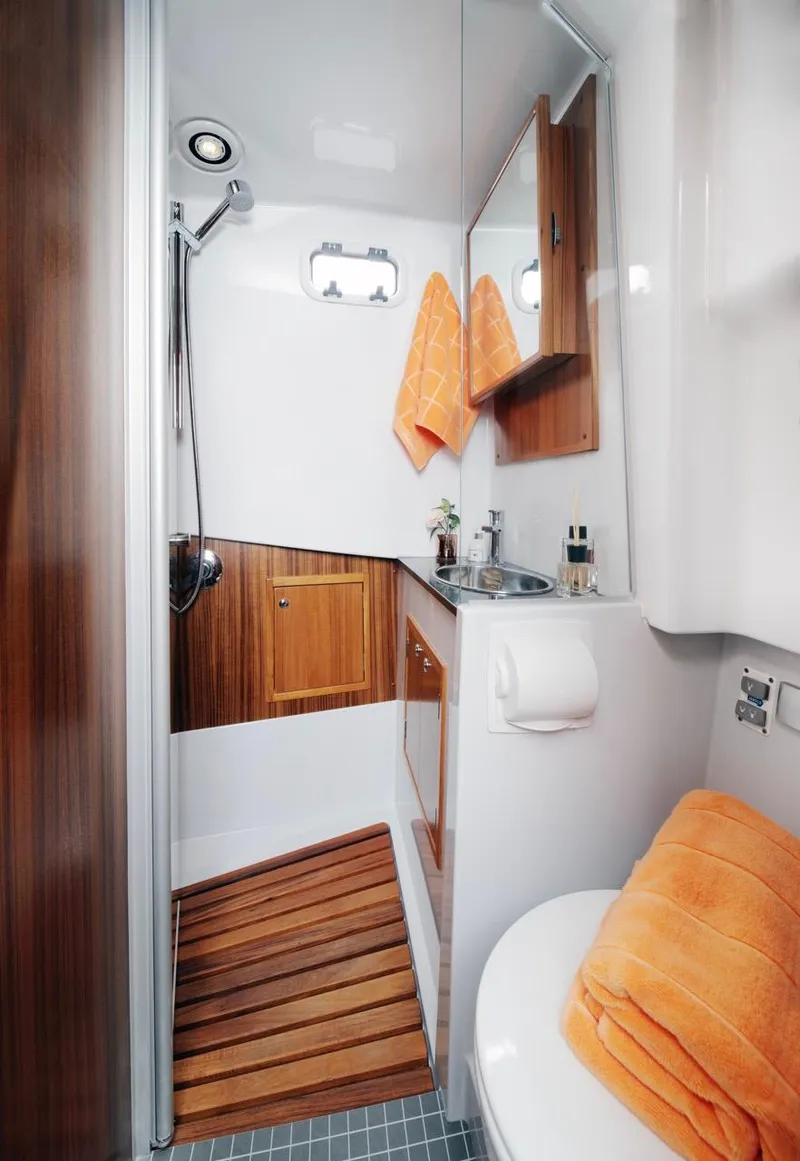 Slide: The Image of Modern bathroom in 2025 Sargo 33 boat with wood accents and orange towels. - 13