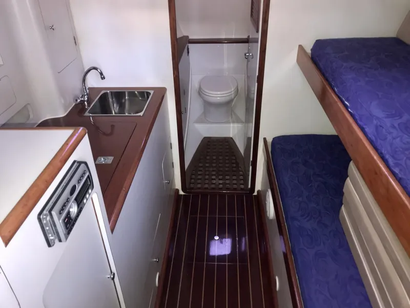 Slide: The Image of 1993 Gamefisherman 34 Express cabin interior with kitchenette, bunk beds, and bathroom. - 8