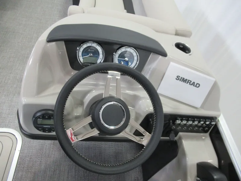 Slide: The Image of 2023 Barletta C22QC boat dashboard with steering wheel and Simrad display. - 7