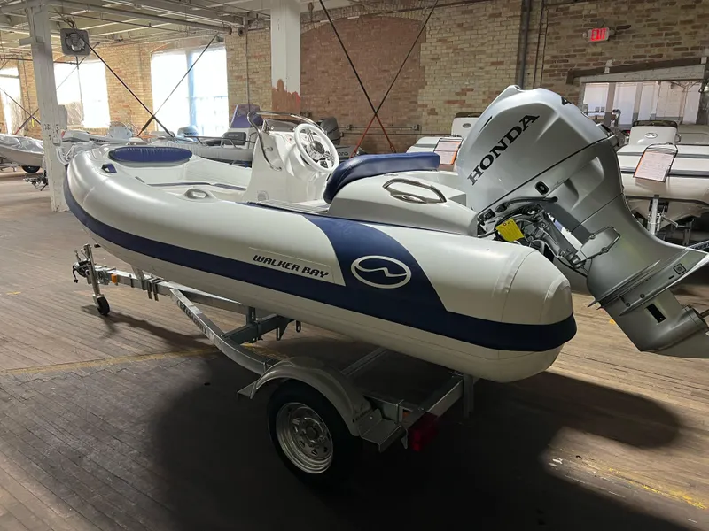 Slide: The Image of 2023 Walker Bay Generation 360 inflatable boat with Honda outboard motor on trailer. - 1