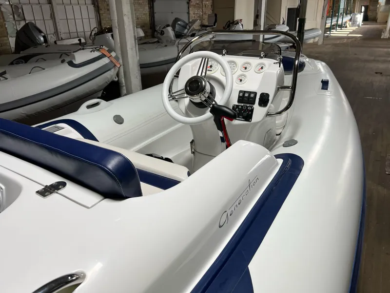 Slide: The Image of 2023 Walker Bay Generation 360 inflatable boat interior with steering console and seating. - 2