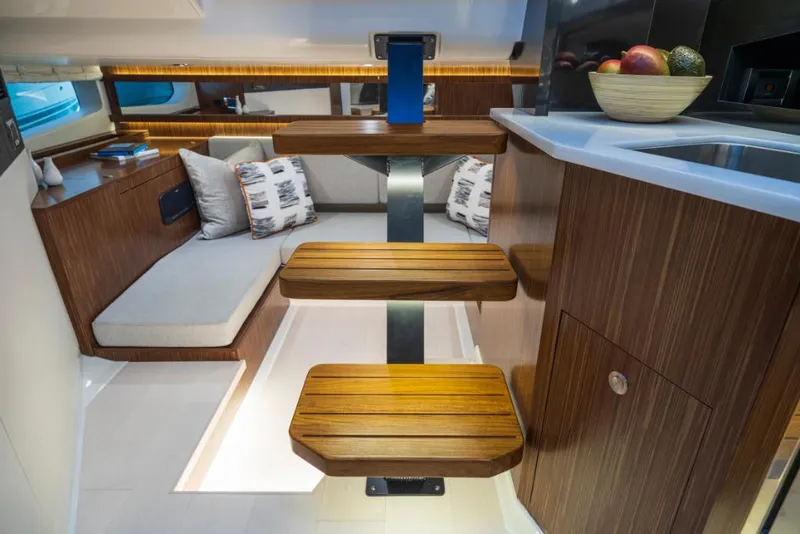 Slide: The Image of Interior of 2023 Sea Ray Sundancer 370 Outboard with wooden steps and cozy seating area. - 28